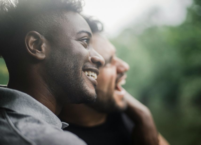 Two men smiling and enjoying time together outdoors